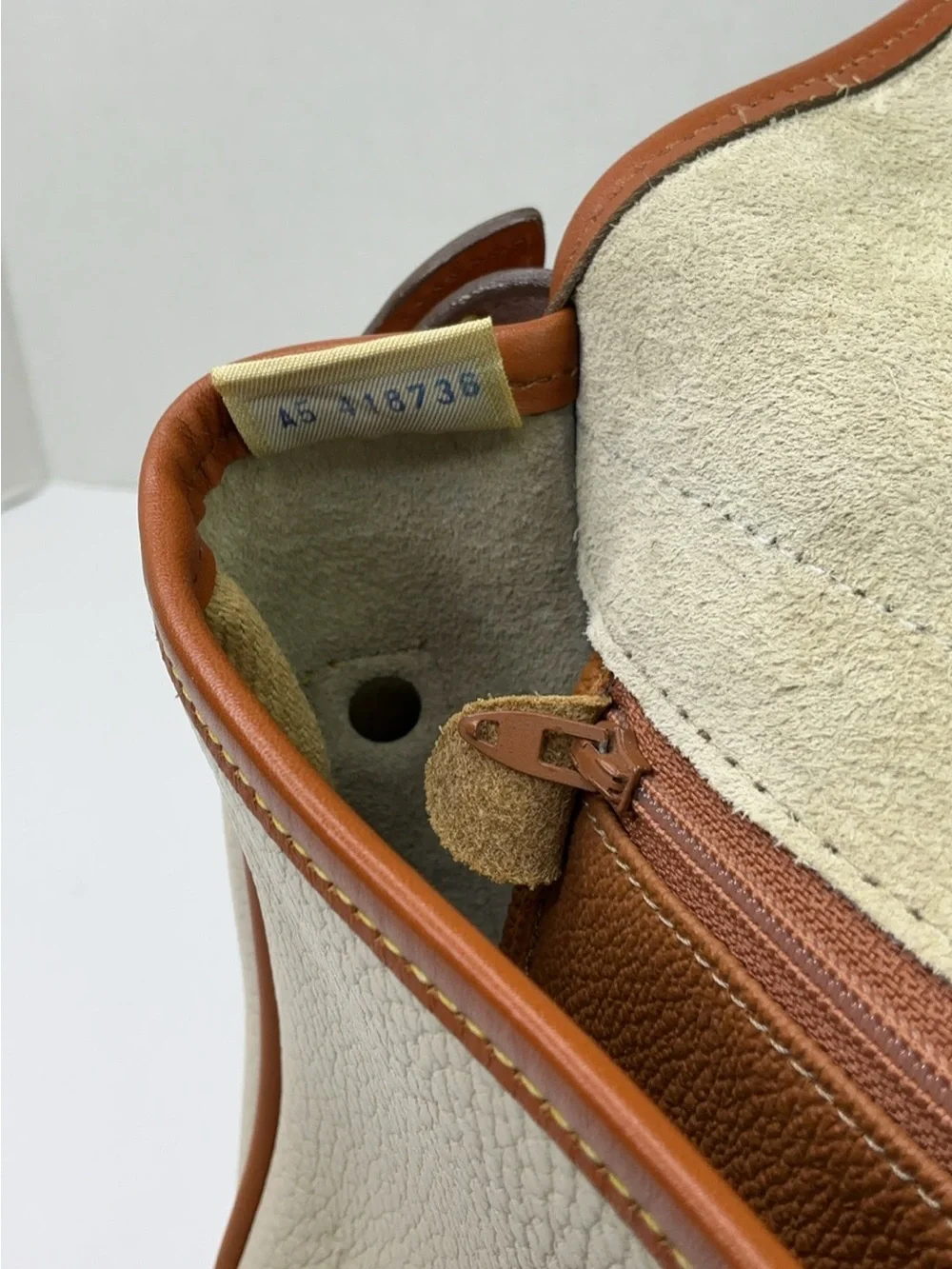 Dooney & Bourke cream and tan pebbled leather saddle bag